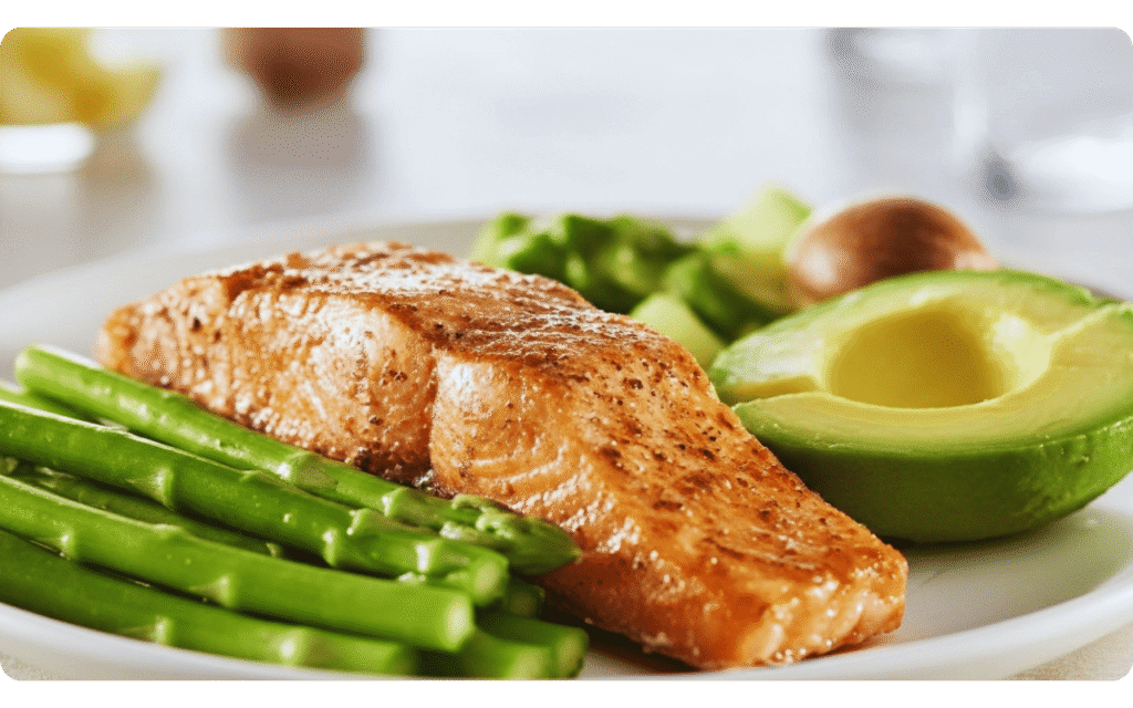 Prato servido com salmão grelhado, abacate e aspargos verdes.