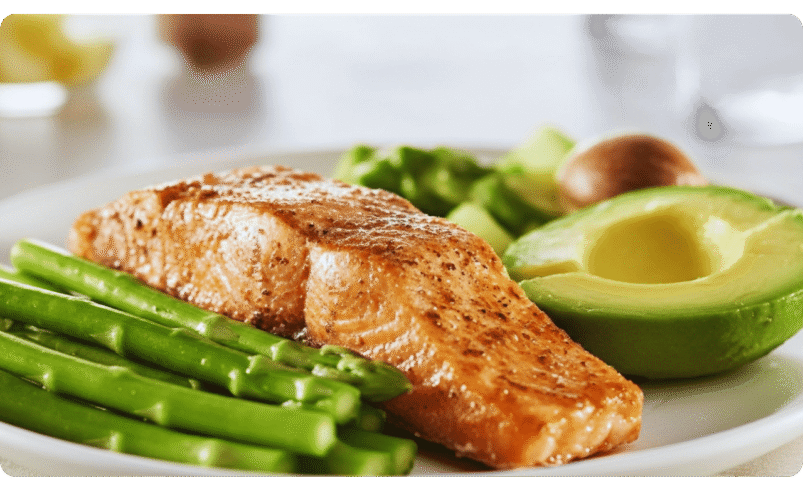 Prato servido com salmão grelhado, abacate e aspargos verdes.