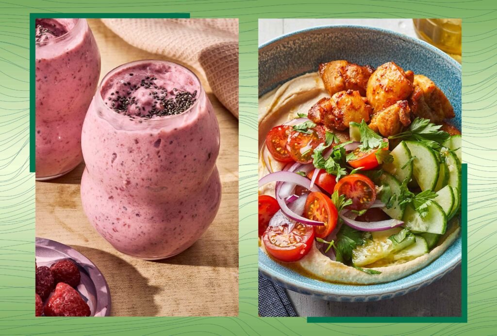 Smoothie rosa em copos e prato de homus com vegetais frescos.