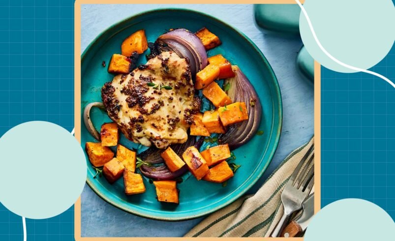 Prato com frango grelhado, cubos de batata-doce assada e fatias de cebola roxa.