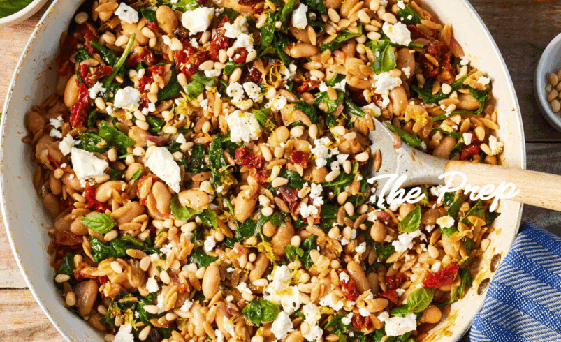 Panela com salada de orzo, vegetais frescos e queijo feta.