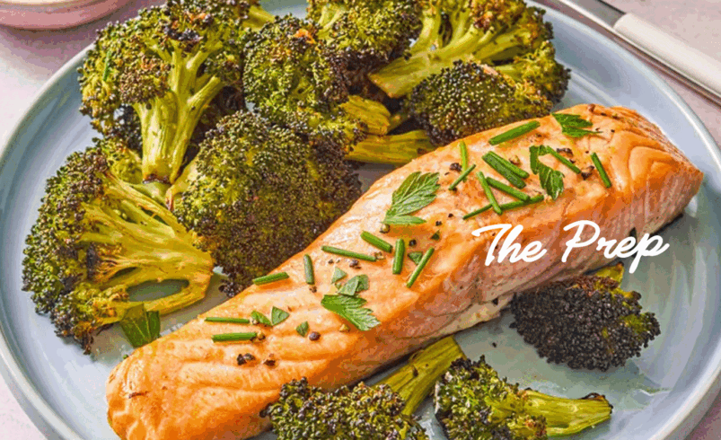 Salmão grelhado com ervas e brócolis assado em prato azul.