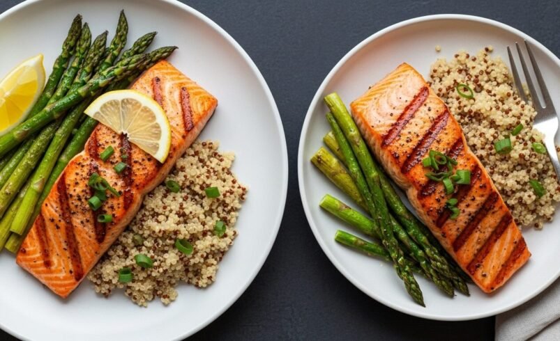 Dois pratos com salmão grelhado, aspargos e quinoa sobre mesa preta.