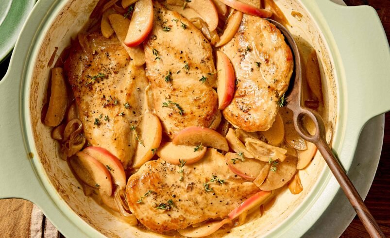 Prato de frango com fatias de maçã e ervas em panela verde