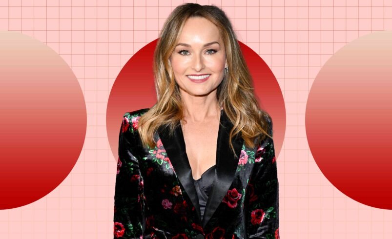 Pessoa usando blazer floral preto em fundo com círculos vermelhos e grade rosa.