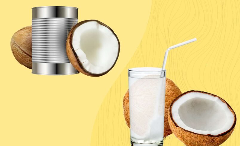 Coco fresco aberto, leite de coco enlatado e copo com canudo.