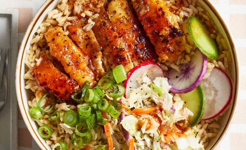 Prato com arroz, frango grelhado e salada fresca colorida.