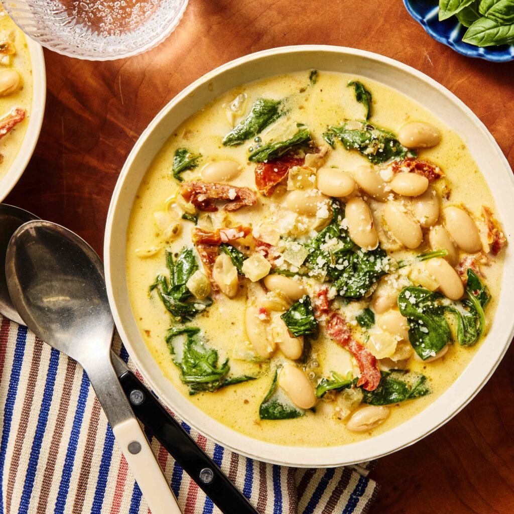 Tigela com sopa cremosa de feijão branco, espinafre e tomates secos.