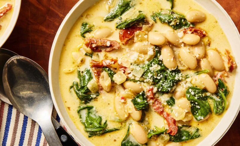 Tigela com sopa cremosa de feijão branco, espinafre e tomates secos.