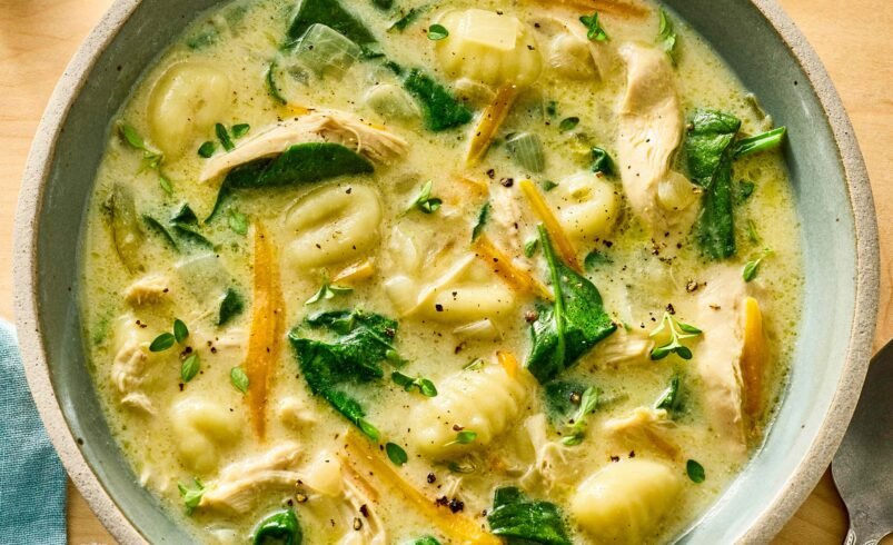 Tigela de sopa cremosa com nhoque, frango e espinafre frescos.