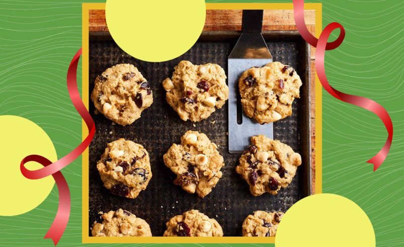 Bandeja com cookies de aveia, frutas secas e nozes sobre fundo verde decorado.