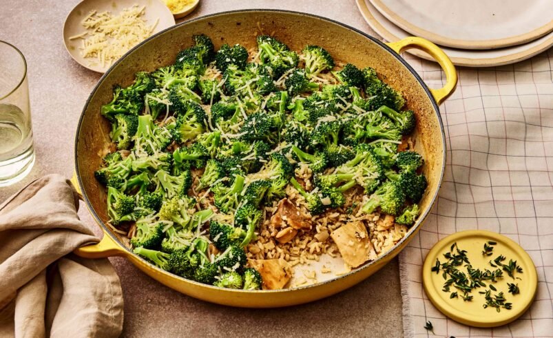 Panela amarela com arroz cremoso, brócolis e queijo ralado.