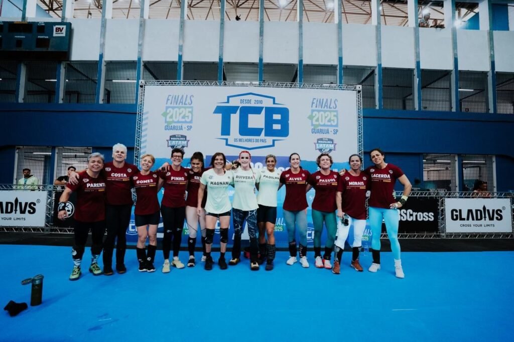 Grupo de atletas posando em frente à estrutura do TCB 2025.