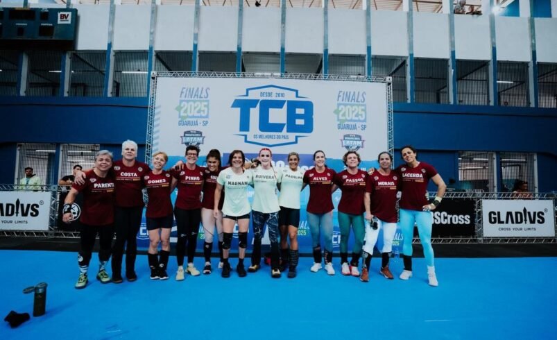 Grupo de atletas posando em frente à estrutura do TCB 2025.