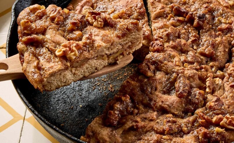 Fatias de bolo de banana com nozes em frigideira de ferro fundido.